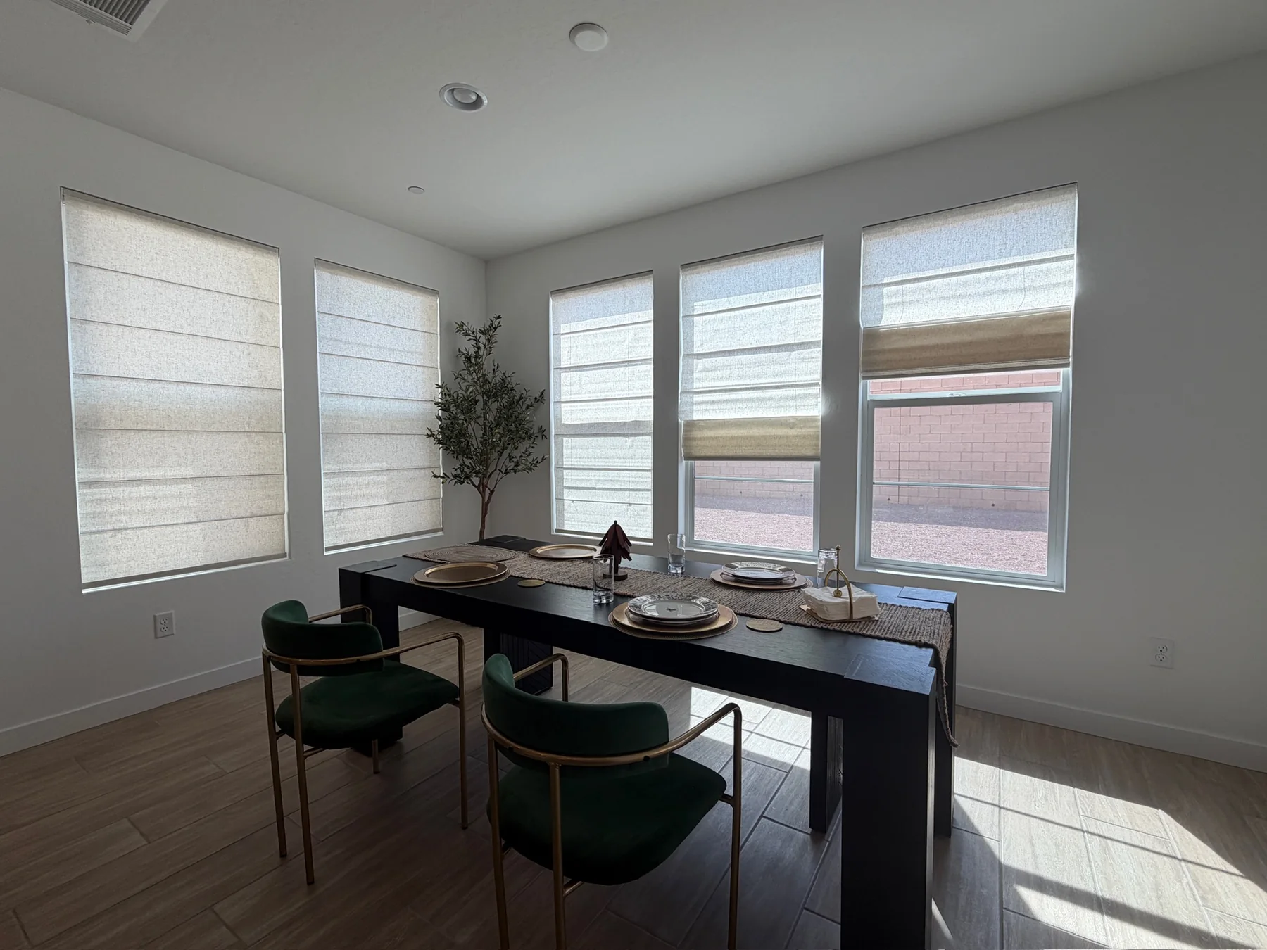 Roman shades installed across a bright dining room